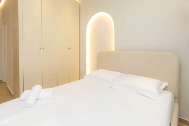 Double bed with a lit arched alcove behind the headboard